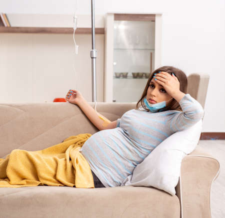 Sick pregnant woman suffering at homeの写真素材