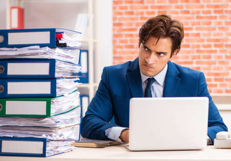 Young elegant man unhappy with too much workの写真素材