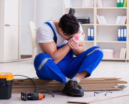 Young worker working on floor laminate tilesの写真素材