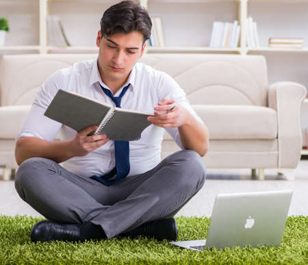 Businessman sitting on the floor in officeの写真素材