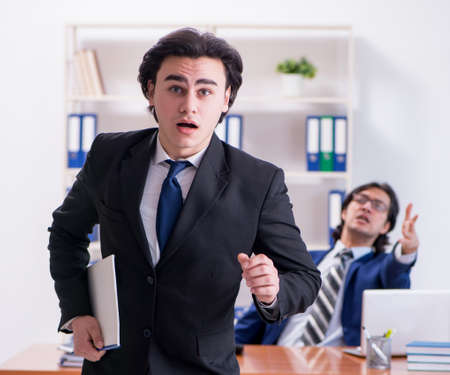 Boss and his male assistant working in the officeの写真素材