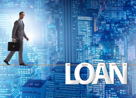 Debt and loan concept with businessman walking on tight ropeの写真素材