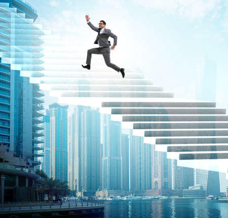 Businessman climbing career ladder over cityの写真素材
