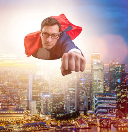 The superhero businessman flying over the cityの写真素材