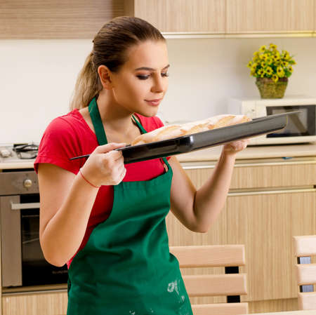 Young female baker working in kitchenの写真素材