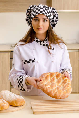 Young female baker working in kitchenの写真素材