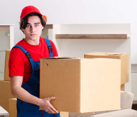 Young male contractor with boxes working indoorsの写真素材