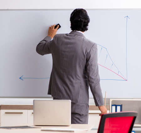 Young handsome businessman in front of whiteboardの写真素材