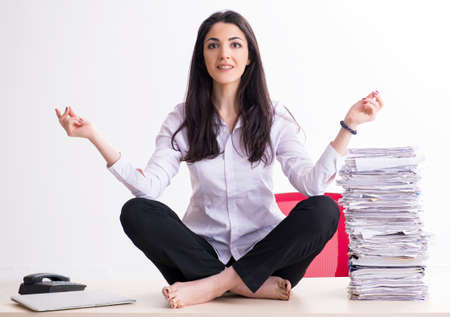 Young female employee doing exercises in the officeの写真素材
