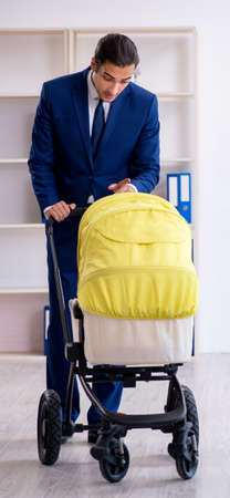 Young father looking after newborn in the officeの写真素材