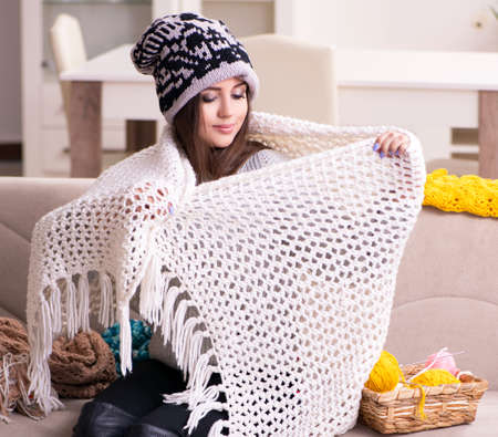 Young beautiful woman knitting at homeの写真素材