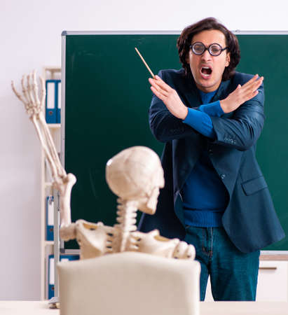 Male teacher and skeleton student in the classroomの写真素材