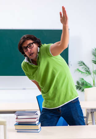 Male student suffering from urge in the classroomの写真素材