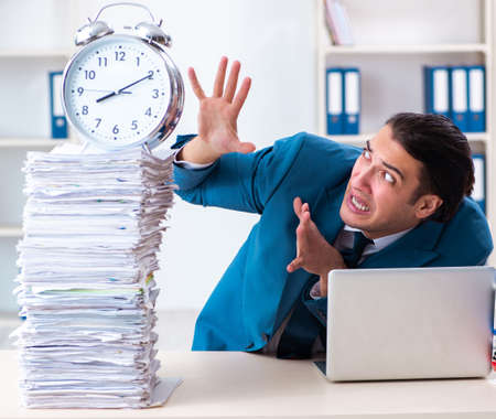 Young male employee unhappy with excessive workの写真素材