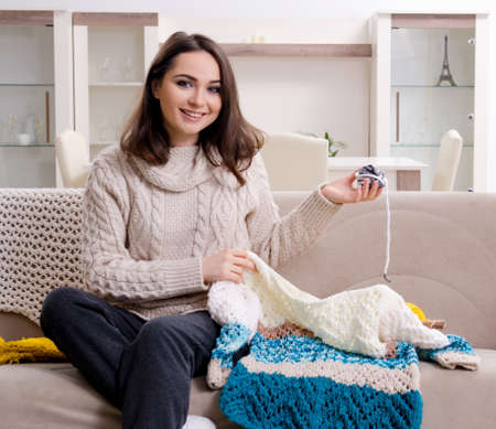 Young beautiful woman knitting at homeの写真素材