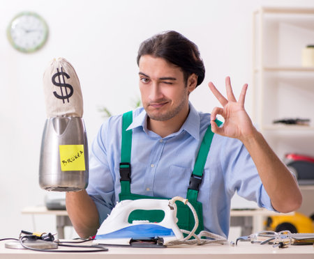 Young man repairman with money sackの写真素材