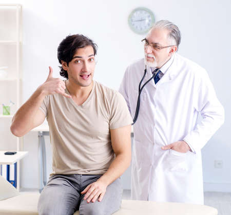 Young male patient visiting old doctorの写真素材