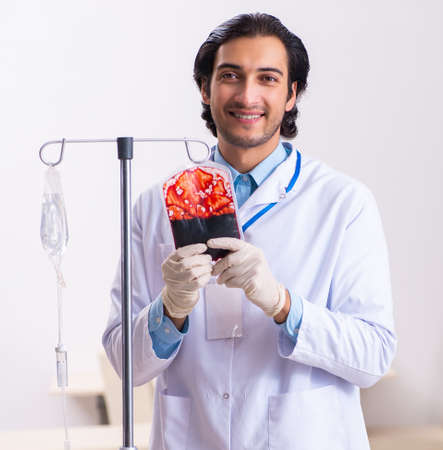 Young male doctor in blood transfusion conceptの写真素材