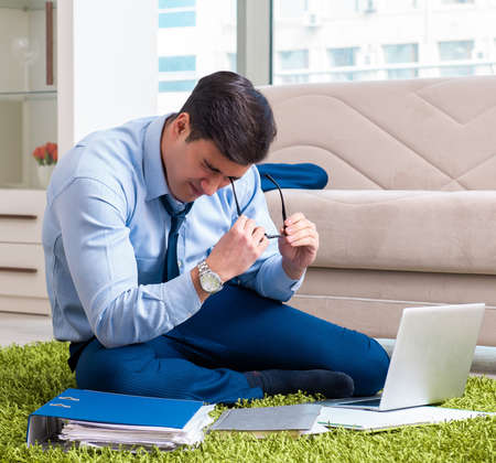 Businessman taking work home and working overtimeの写真素材