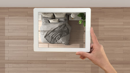 Augmented reality concept. Hand holding tablet with AR application used to simulate furniture products in custom architecture design, black ink sketch, bedroom, top view, plan, aboveの写真素材