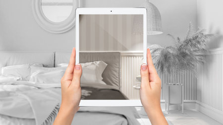 Hands holding tablet showing classic bedroom and lounge, total blank project background, augmented...