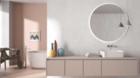 Blur background, cozy minimalist bathroom, washbasin with mirror, bathtub, tiles and concrete walls,...
