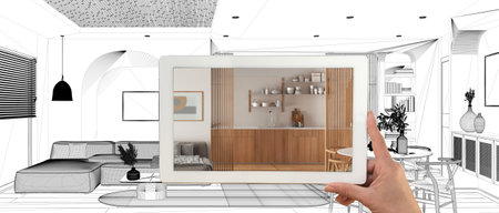 Augmented reality concept. Hand holding tablet with AR application used to simulate furniture products in custom architecture design, black ink sketch, living, dining room and kitchenの写真素材