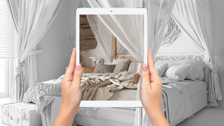 Hands holding tablet showing bohemian bedroom in boho style, total blank project background,...