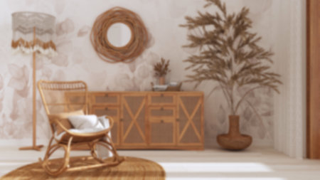 Blurred background, boho chic living room, rattan chest of drawer and rocking chair on jute carpet....