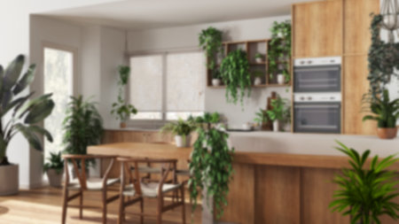 Blurred background, modern wooden kitchen with island and chairs. Biophilic concept, many houseplants. Urban jungle interior designの写真素材