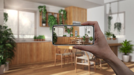 Hand holding smart phone, AR application, simulate furniture and interior design products in real home, architect designer concept, blur background, modern kitchenの写真素材