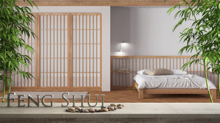 Wooden vintage table shelf with pebble balance and 3d letters making the word feng shui over minimal white bedroom with double bed, zen concept interior designの写真素材