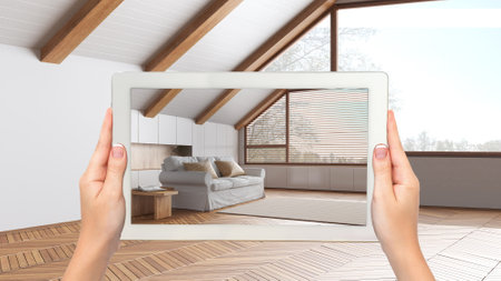 Augmented reality concept. Hand holding tablet with AR application used to simulate furniture and design products in empty wooden interior, minimal japandi living roomの写真素材