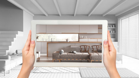 Augmented reality concept. Hand holding tablet with AR application used to simulate furniture and...