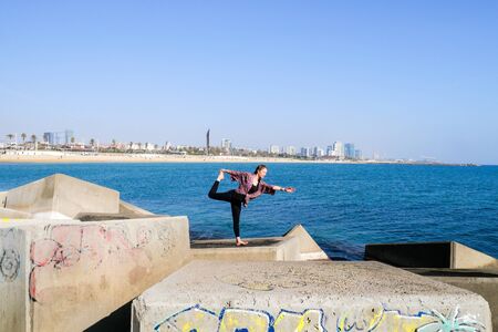 A girl doing some yoga positions and routines in different spots in Barcelona.の写真素材