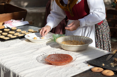 woman preparing dough to make sweet rolls in typical costumeの写真素材