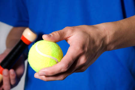 hands holding tennis ball and racket as cutoutの写真素材