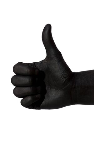a black painted hand is doing a thumbs up gesture, on whiteの写真素材