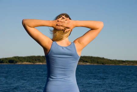 a young european woman stands in front of the sea and relaxesの写真素材
