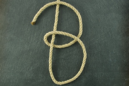 a B of rope lying on a slate table, symbolizing education and writing