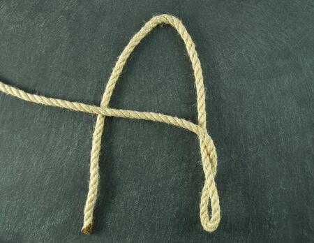 an A of rope lying on a slate table, symbolizing educationの写真素材