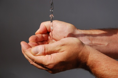 two male hands absorbing clear waterの写真素材