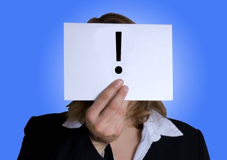 business woman holding tag with an exclamation mark on it, blue backgroundの写真素材