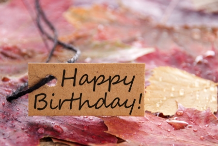 a brown happy birthday banner with autumn leaves as backgroundの写真素材