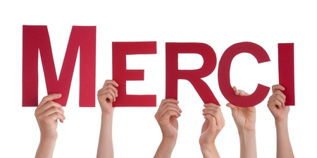 Many Hands Holding the French Word Merci, Which Means Thanks, Isolated