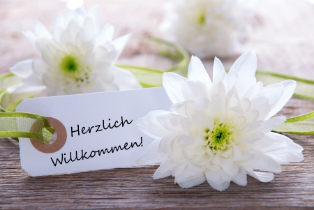 White Label with white flowers and the German Words Herzlich Willkommen which means Welcomeの写真素材
