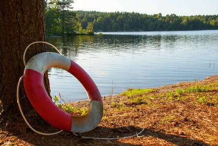 Lifesaver in the Nature on a Lake with green Trees around, summerの写真素材