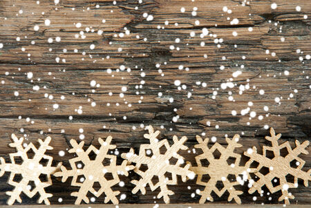 Golden Christmas Snowflakes on Wood with Snowの写真素材