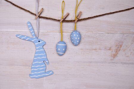 One Blue Easter Bunny With Stripes Hanging On A Line With Two Blue Easter Eggs Which Are Dotted And...