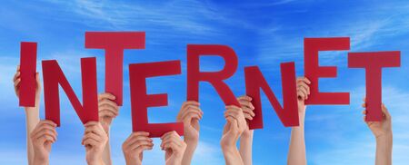 Many Caucasian People And Hands Holding Red Letters Or Characters Building The English Word Internet On Blue Skyの写真素材